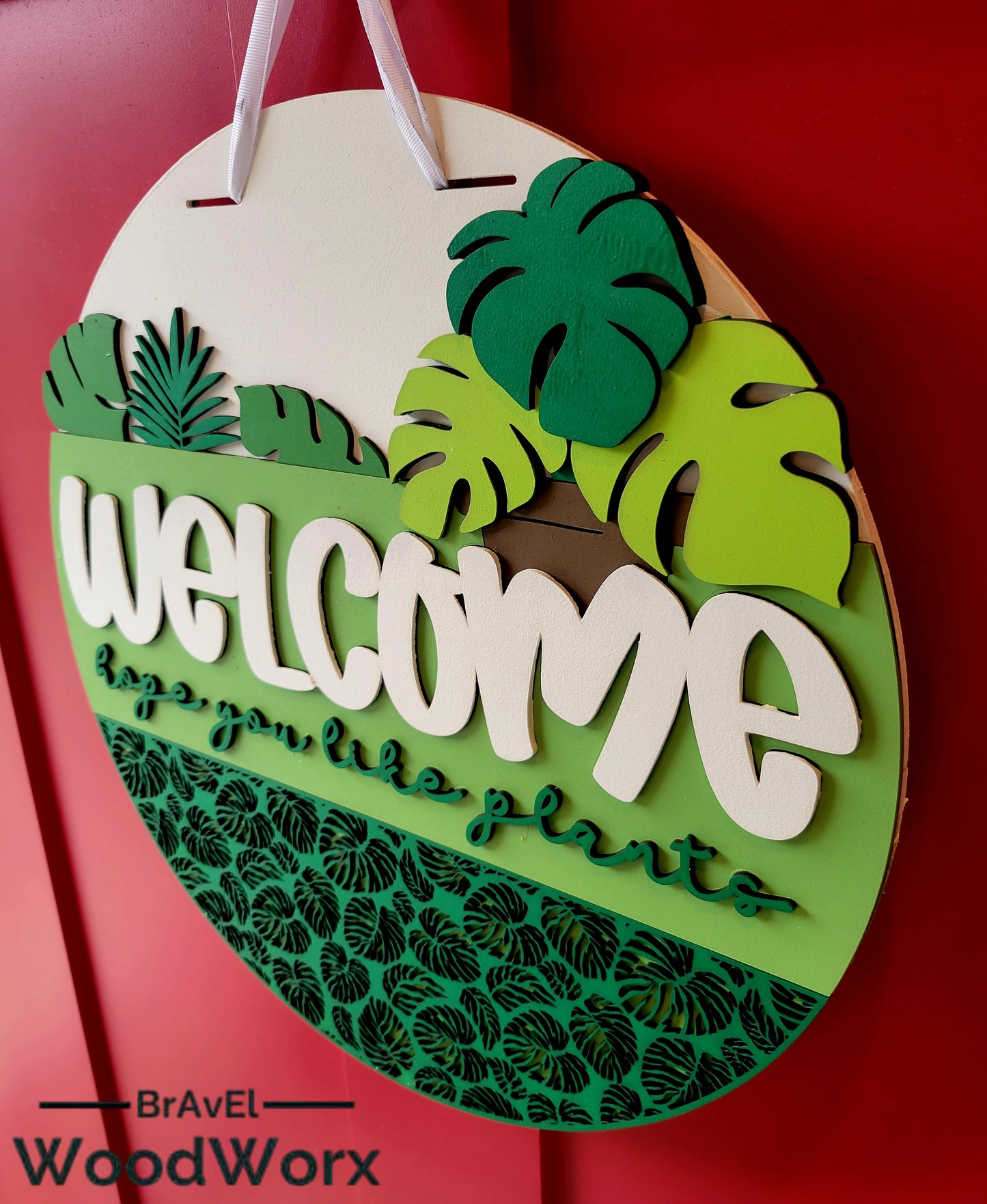 Laser cut wooden door hanger displaying Welcome Plant Lovers with 3D tropical leaf accents