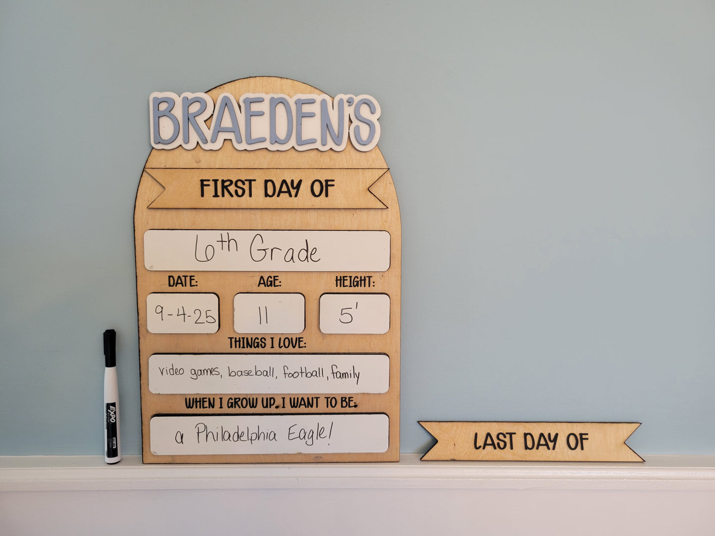 Wooden sign for the first day of school with personal information on a light blue background