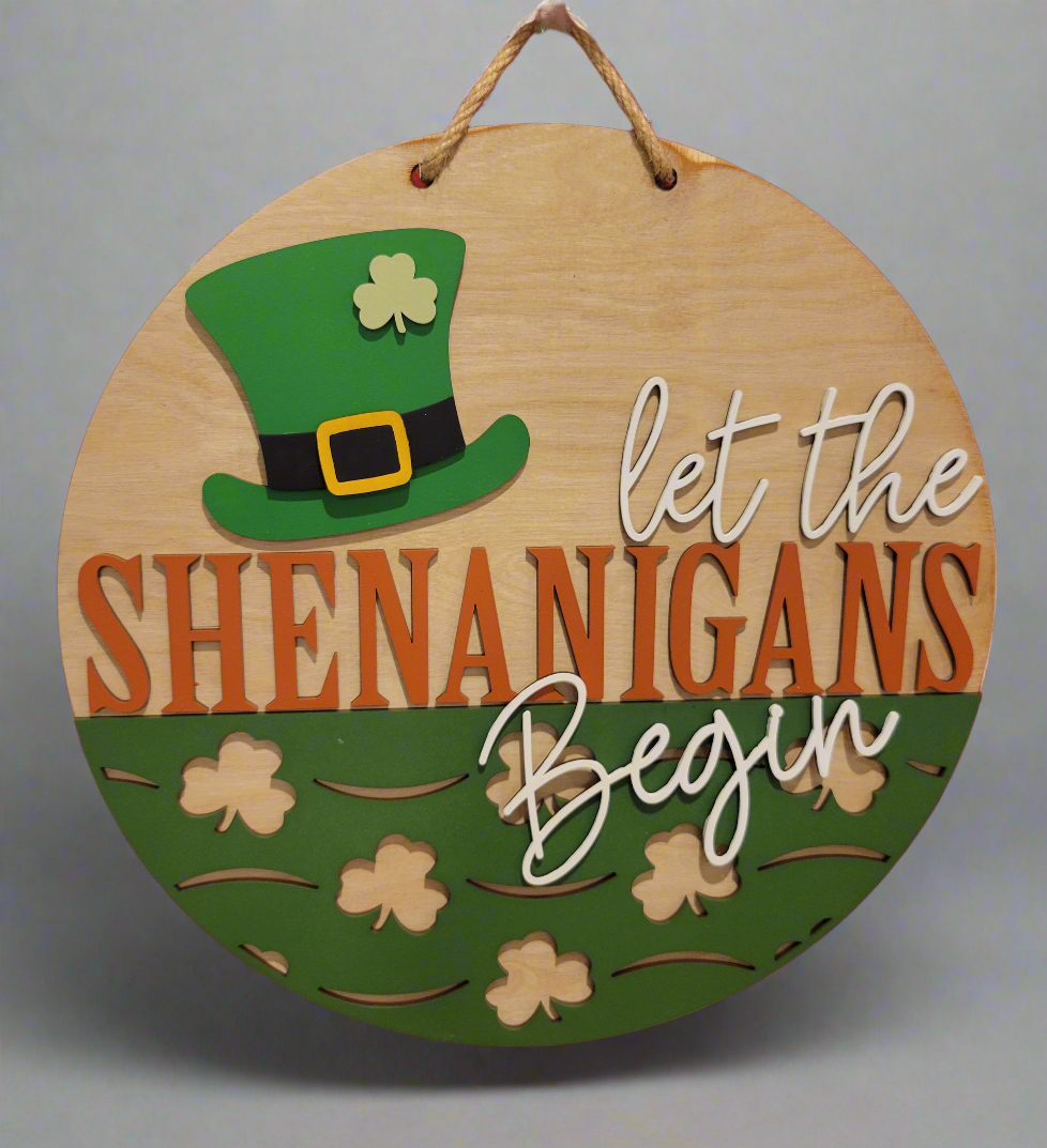 A festive St. Patrick's Day door hanger featuring a four-leaf clover design and the message 'Happy St. Patrick's Day! May your day be as lucky as a four-leaf clover!' The back of the hanger includes an Irish blessing with decorative shamrocks. Shadow