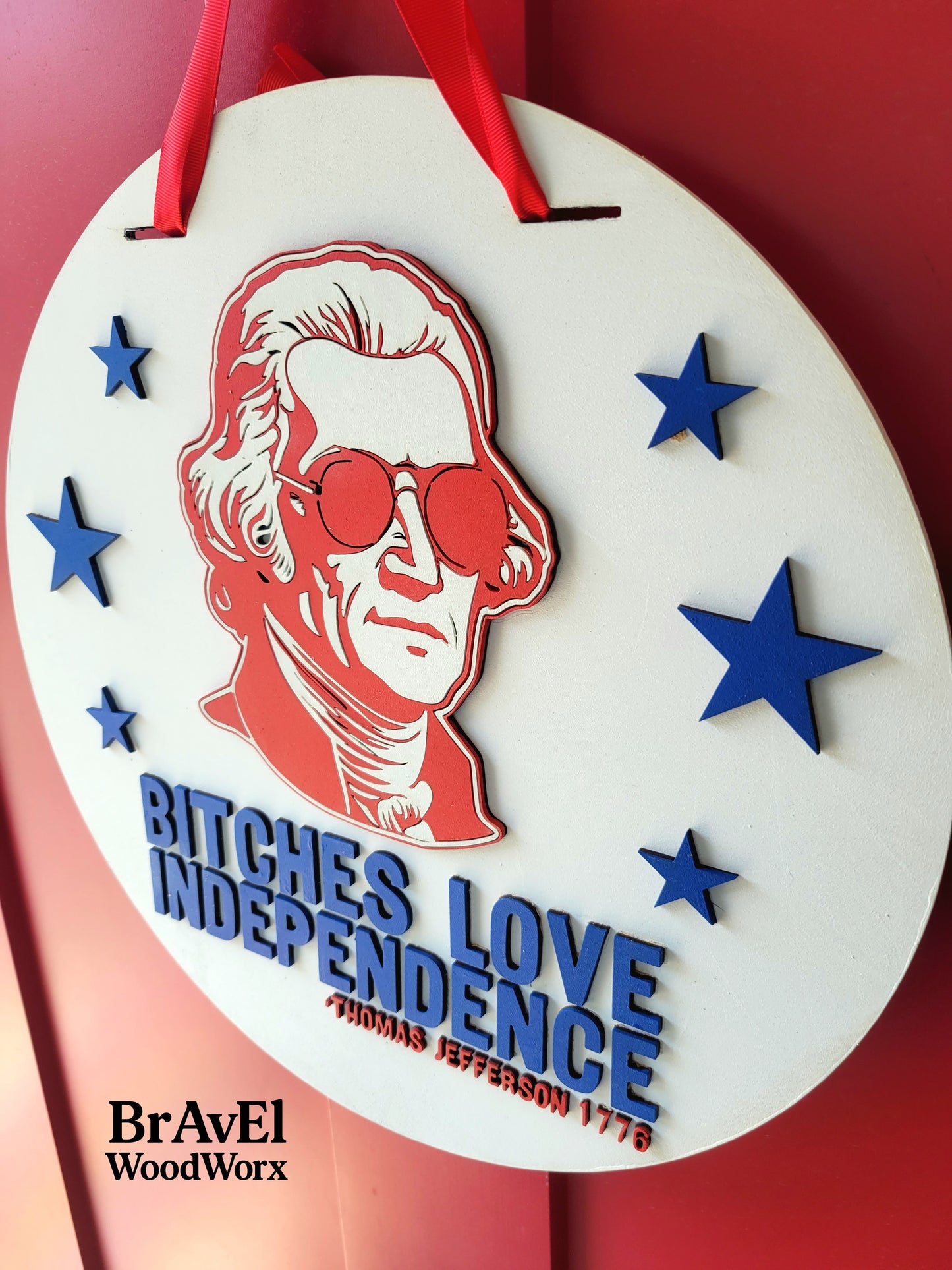 Decorative item with a portrait and text on a red background, featuring the brand 'BraveEl WoodWorx'.