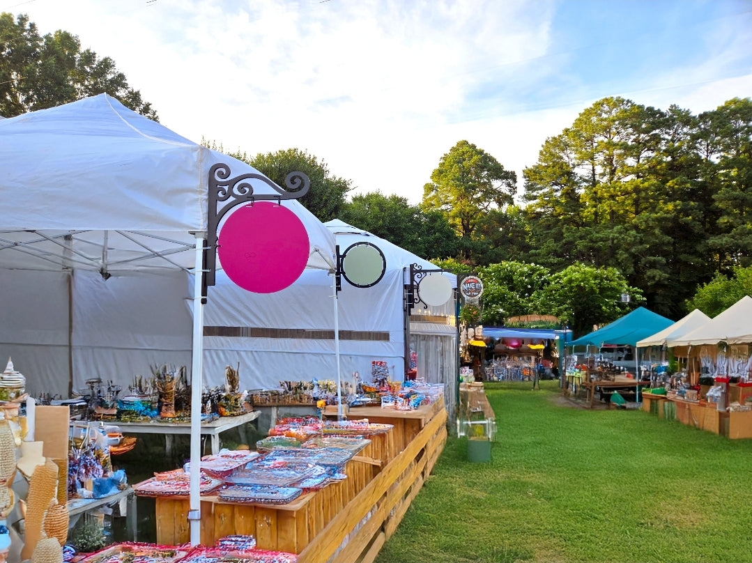 Outdoor event with tents, tables, and chairs under a clear sky