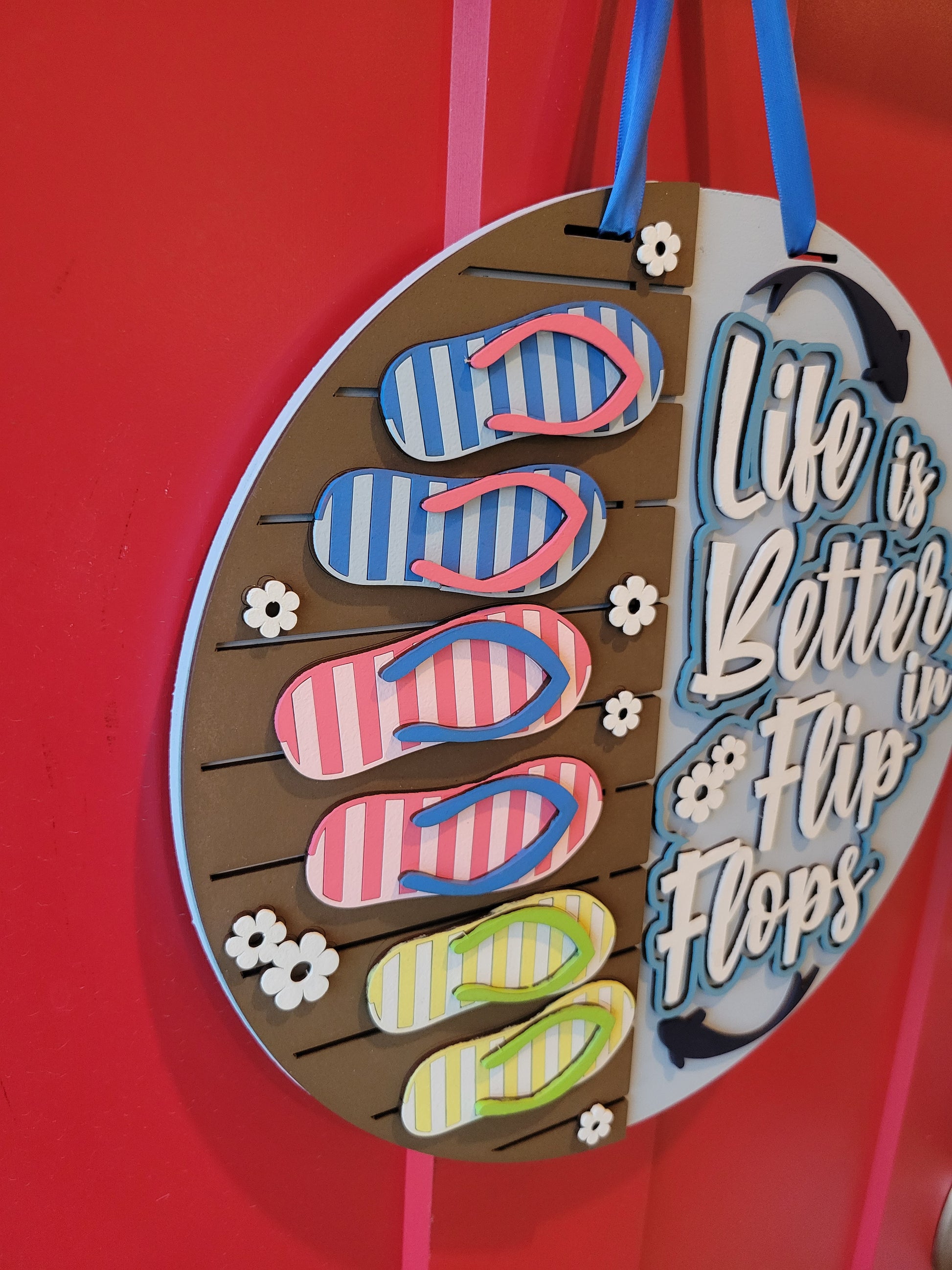 A rectangular wooden sign with a coastal vibe, featuring the text "Life is Better in Flip Flops" written in a playful, beach-inspired font. The background is painted in soft turquoise with a weathered wood texture, accented by illustrations of flip flops and small seashells. Perfect for beach houses, patios, or summer decor. Side view