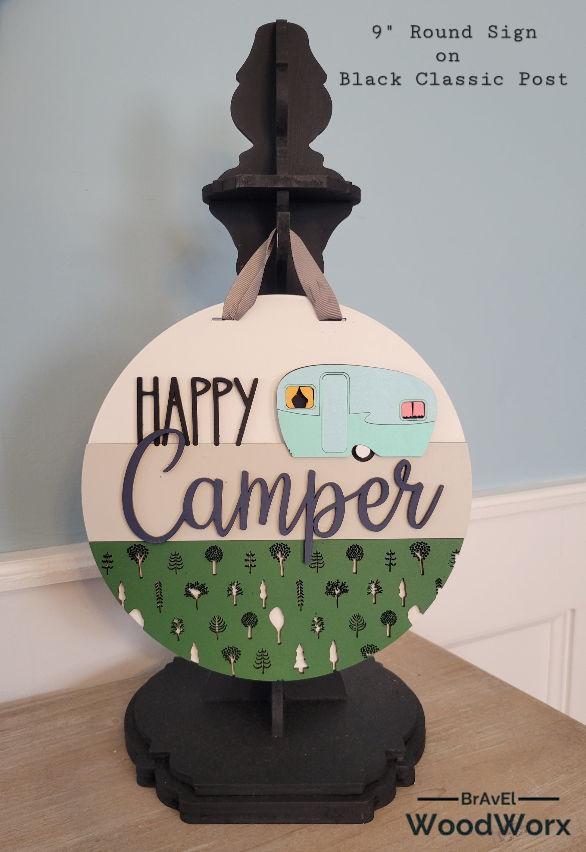 Handmade 'Happy Camper' wall door sign displayed on a post, featuring a charming rustic design with vibrant colors, a playful camper graphic, and personalized text. Perfect for adding a cozy, outdoor-inspired touch to any space. Black Post