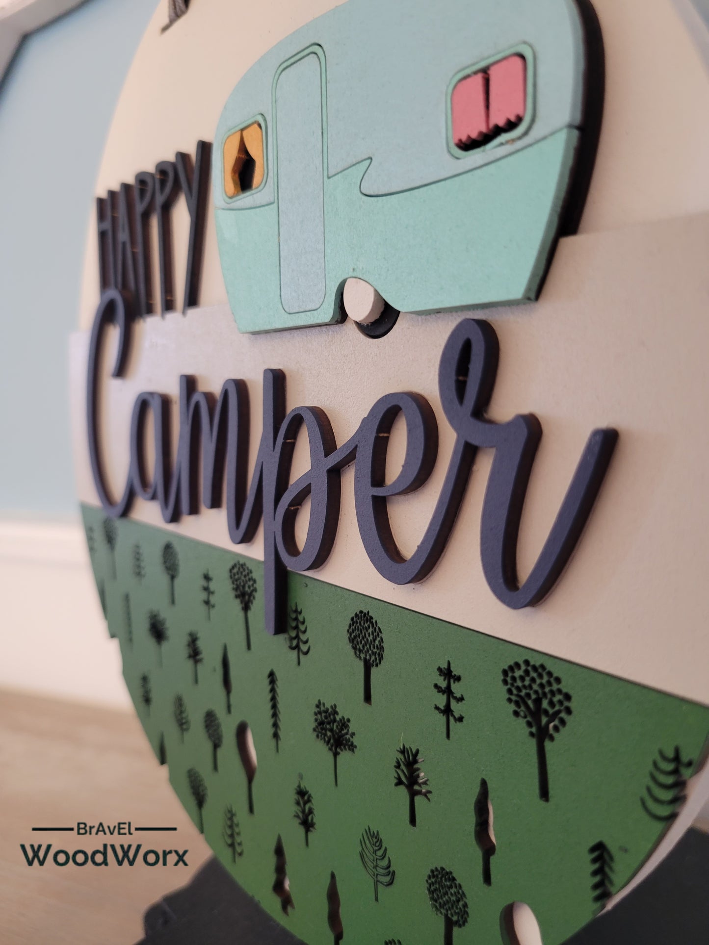 Handmade 'Happy Camper' wall door sign displayed on a post, featuring a charming rustic design with vibrant colors, a playful camper graphic, and personalized text. Perfect for adding a cozy, outdoor-inspired touch to any space. Close Up