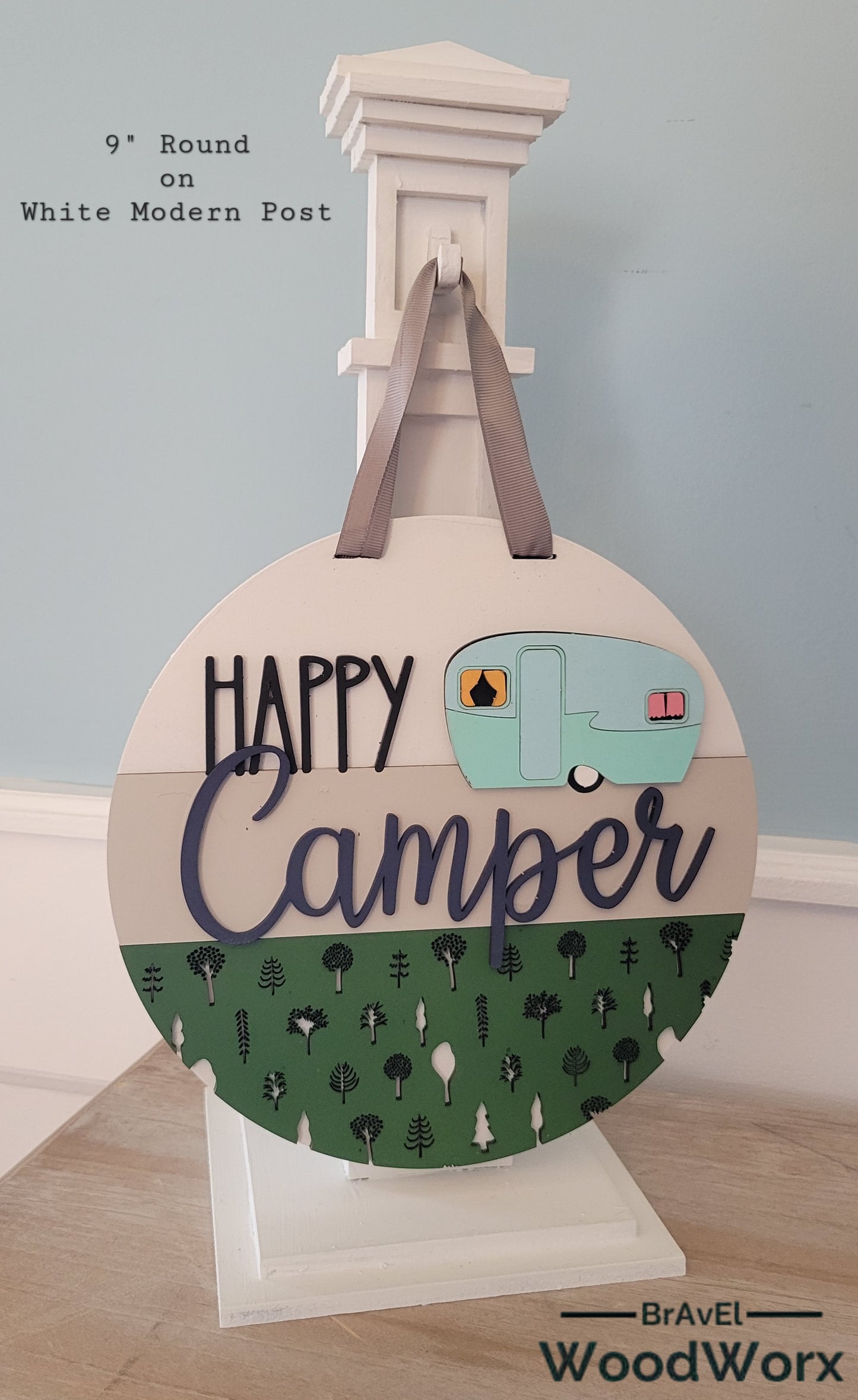 Handmade 'Happy Camper' wall door sign displayed on a post, featuring a charming rustic design with vibrant colors, a playful camper graphic, and personalized text. Perfect for adding a cozy, outdoor-inspired touch to any space. White Post