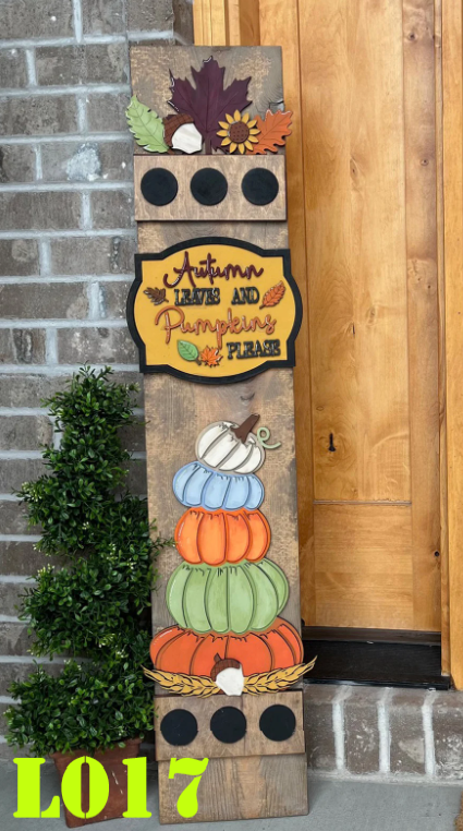Decorative wooden sign with autumn theme and pumpkins, leaning against a brick wall.