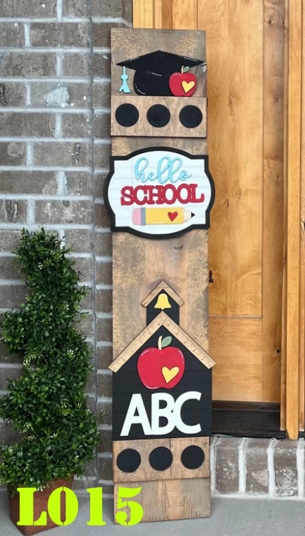 Wooden decorative sign with school-themed elements against a brick wall.