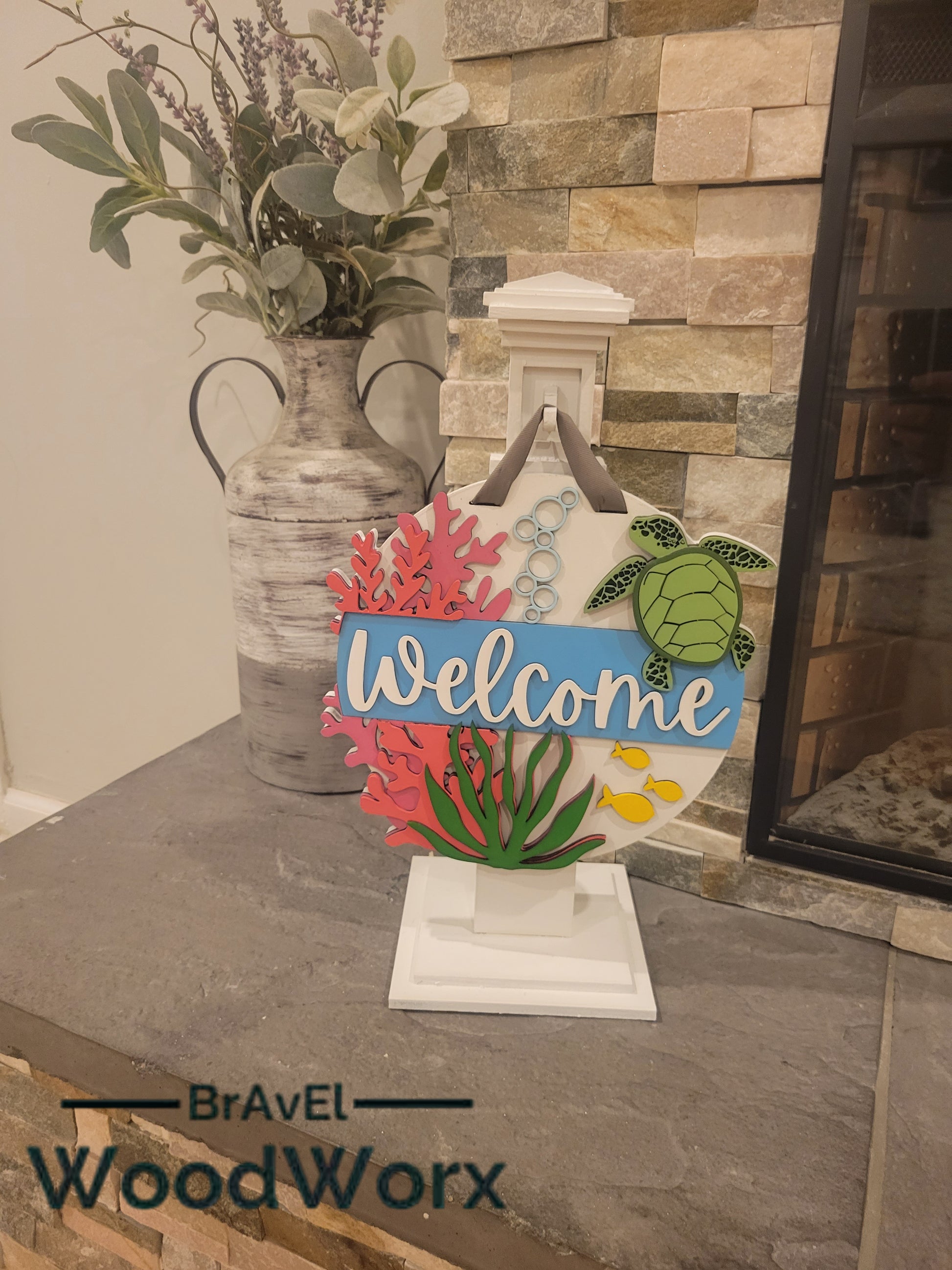 Welcome Sea Turtle Sign: A beautifully crafted wooden sign featuring a laser-engraved sea turtle design with the word 'Welcome' elegantly displayed. The sign has a coastal theme with soothing colors, perfect for beach houses, marine enthusiasts, or as a welcoming decorative piece for any space. Fire place