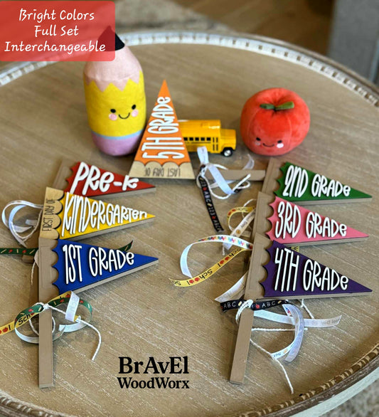 Educational-themed wooden flags with grade levels and a school bus toy on a wooden surface, branded 'BrAvEl WoodWorx'.