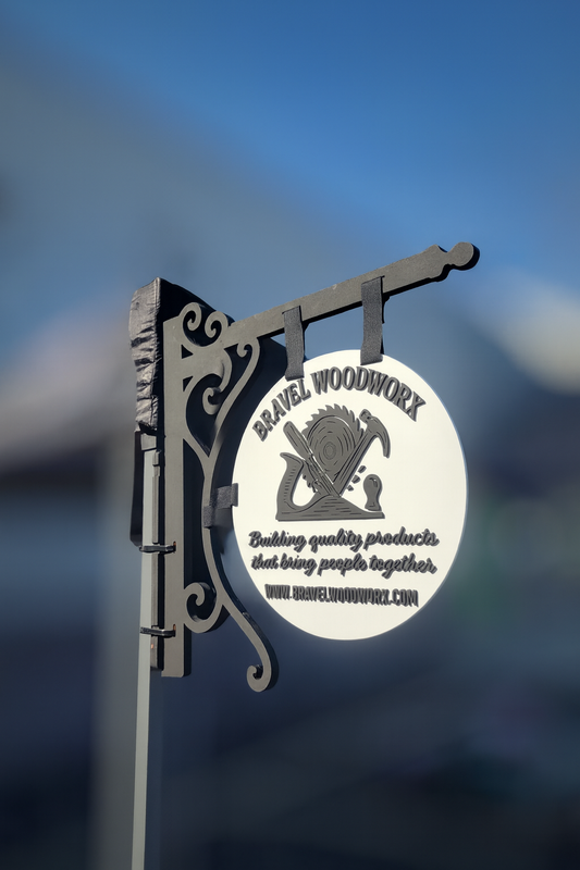 Metal sign with 'Brave Woodwork' logo and text against a blurred blue background