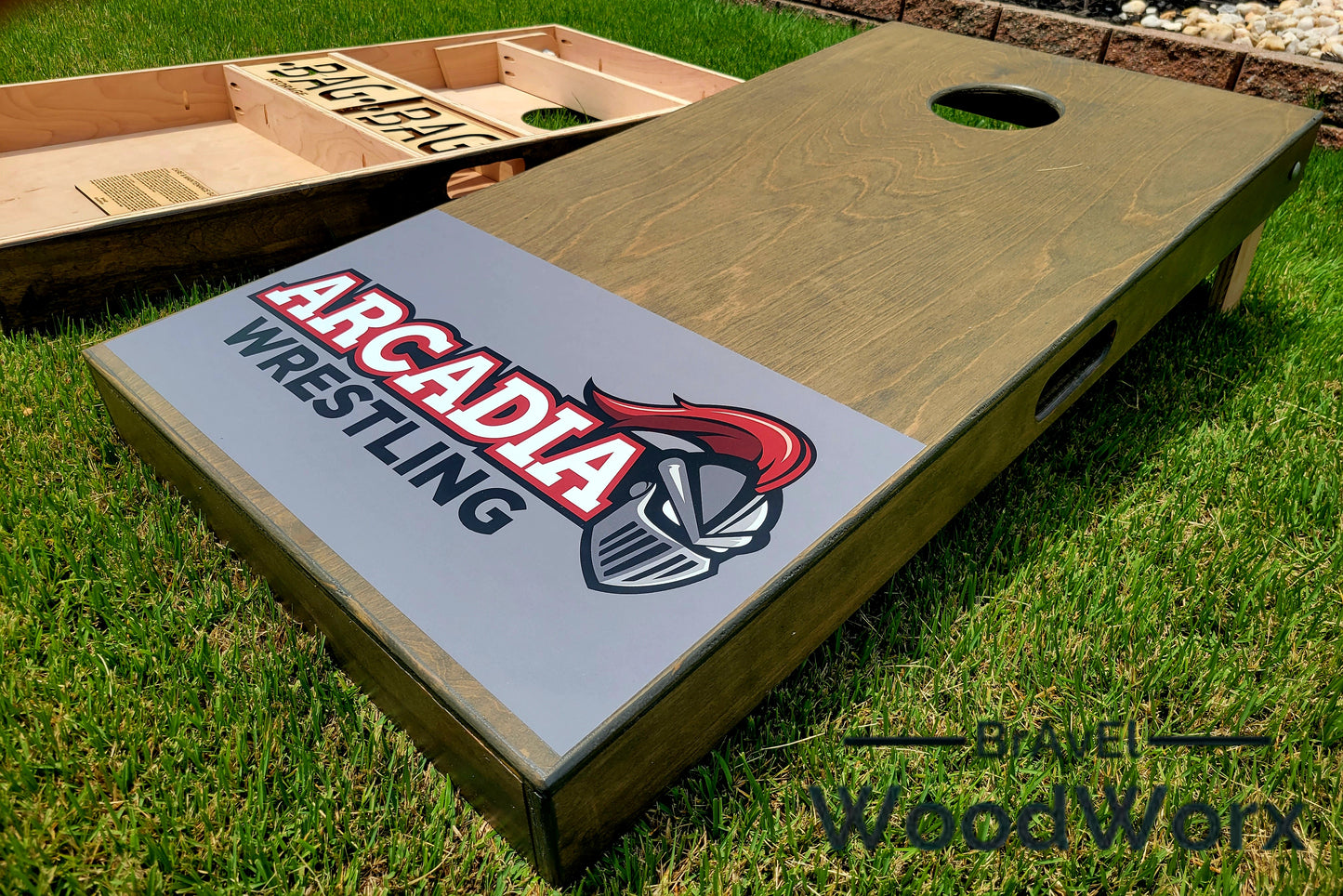 Cornhole board with 'Arcadia Wrestling' design on grass