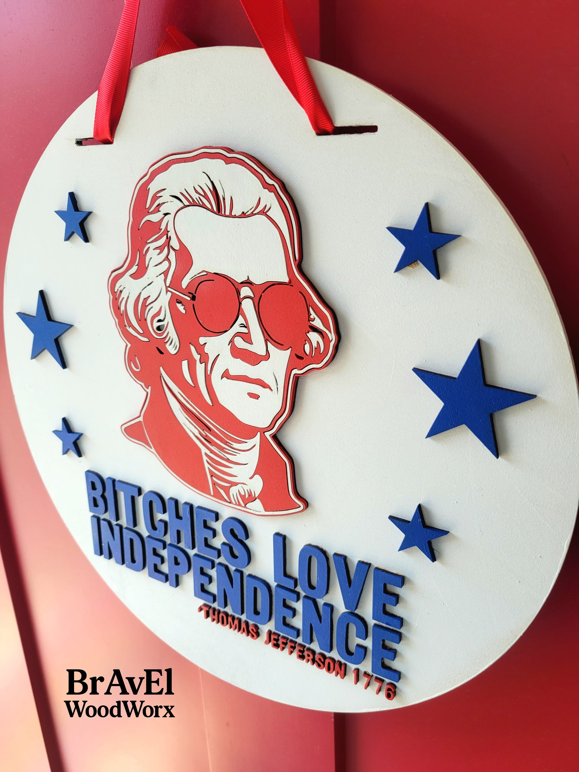 Decorative item with a portrait and text on a red background, featuring the brand 'BraveEl WoodWorx'.