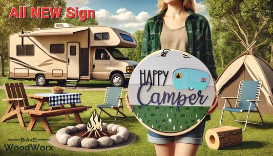 A handcrafted painted wood sign with the text 'HAPPY CAMPER' and an illustration of a camper, displayed in an outdoor setting with a woman holding it. The sign also features elements like a firepit and a grill, suggesting a camping theme.