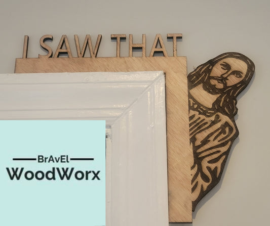 A wooden door trim hanger with a carved image of Jesus and the text 'I SAW THAT', mounted on a white door frame, with a logo 'BRAVEL WOODWORX' at the bottom.