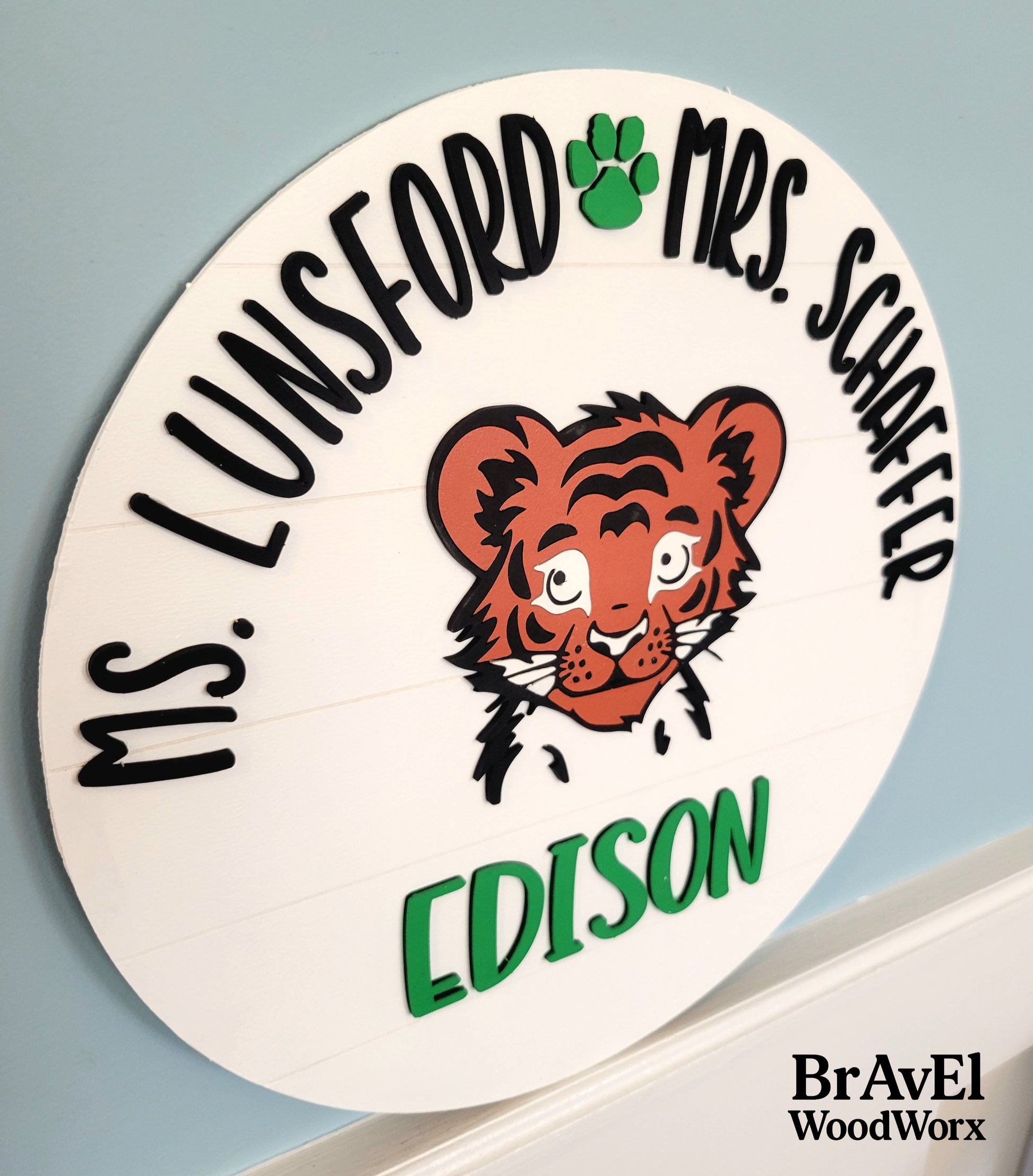 Circular sign with a tiger illustration and text on a light blue background, featuring the brand 'Brave1 WoodWorx'.