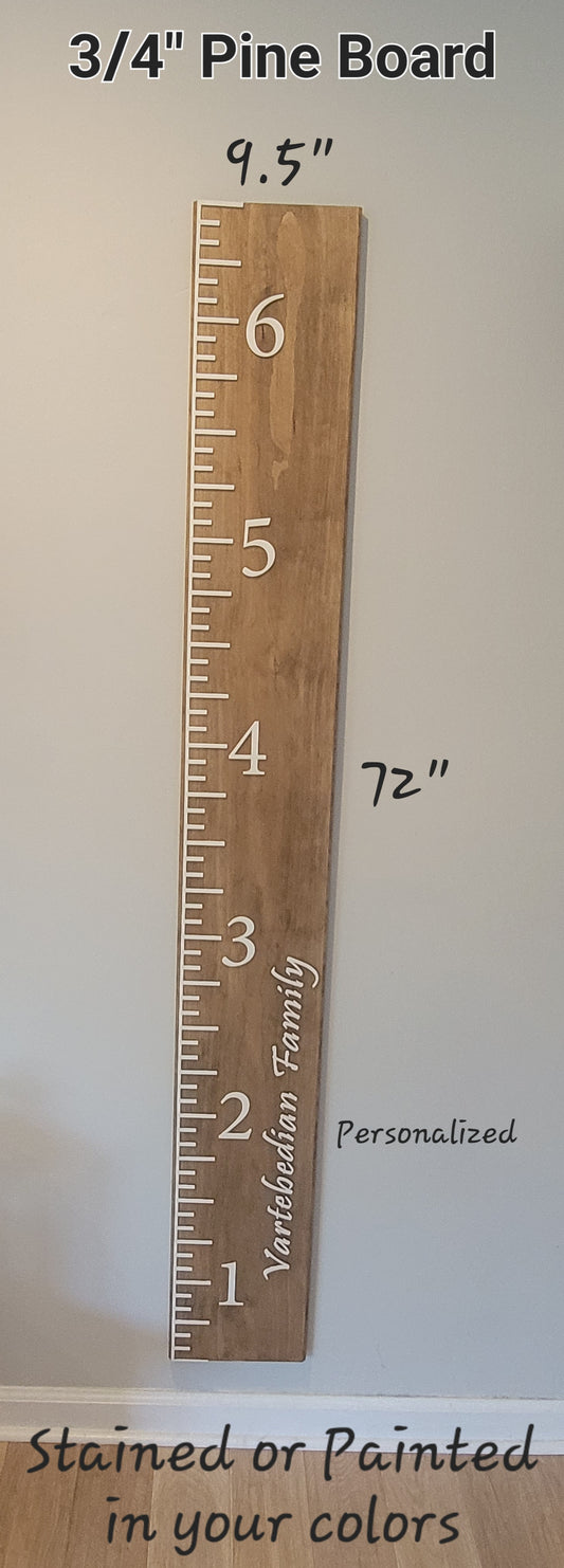 A wooden growth chart board with markings in white, mounted on a wall, with text indicating the height in inches and the board size of 3/4 inch by 9.5 inches.