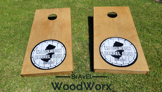 Two wooden cornhole boards with a monogram and the text 'Middourbon Barrel Club' engraved on them, placed on grass with the brand 'BrAvEl WoodWorx' visible.