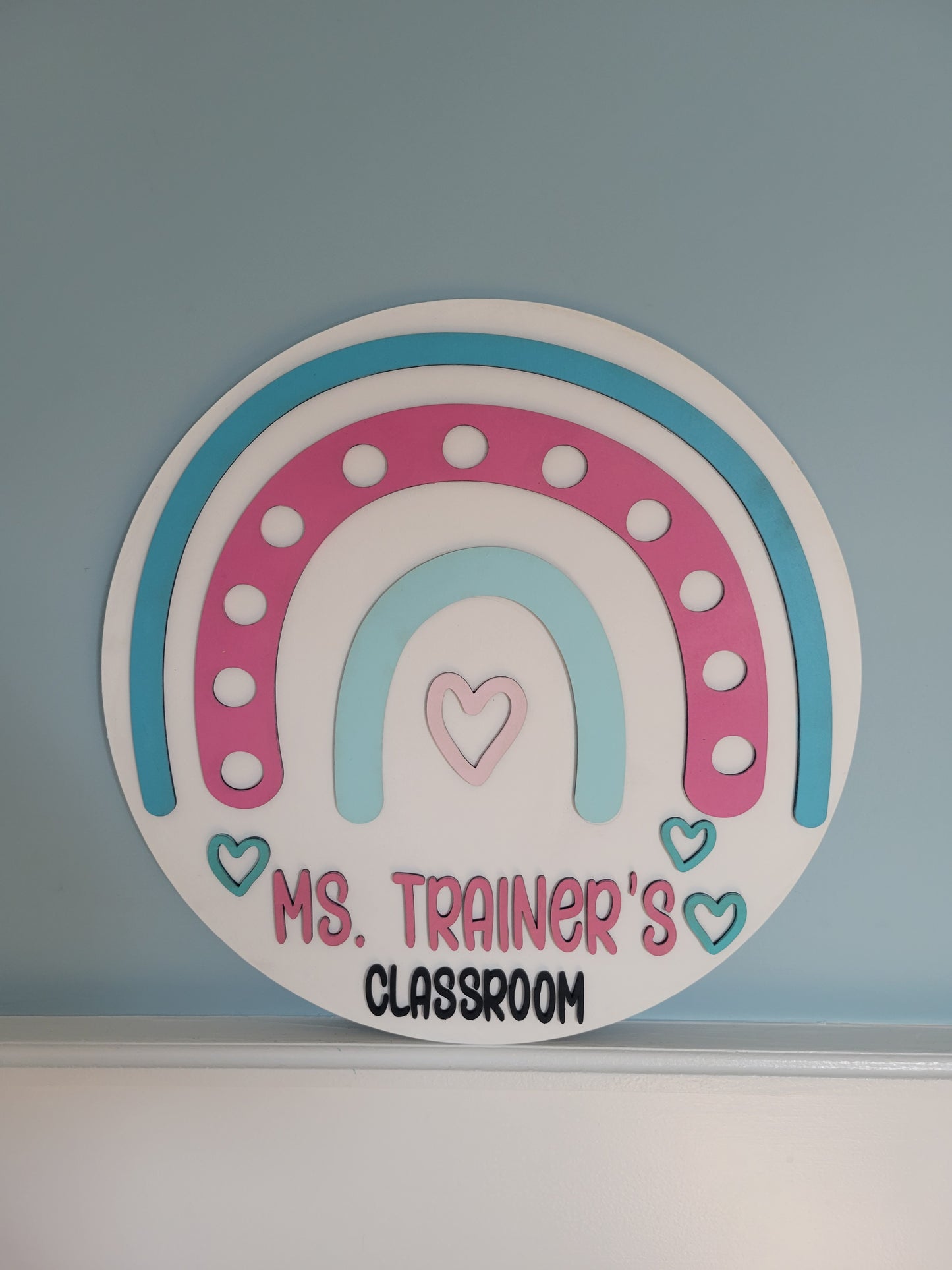 Decorative sticker with a rainbow design and text on a blue wall