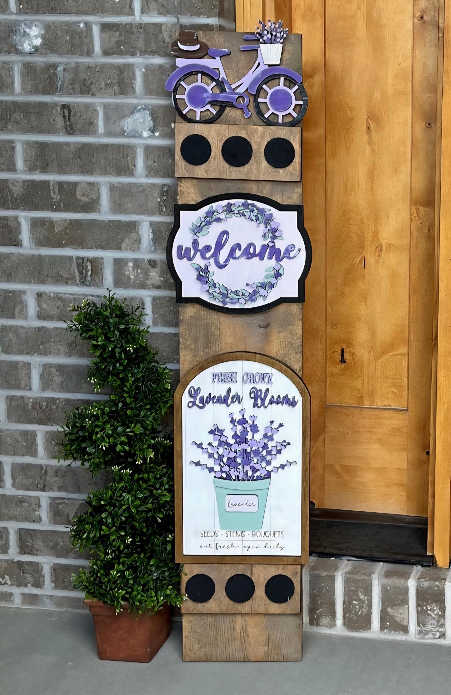 Decorative sign with lavender theme and 'welcome' text on a brick wall background