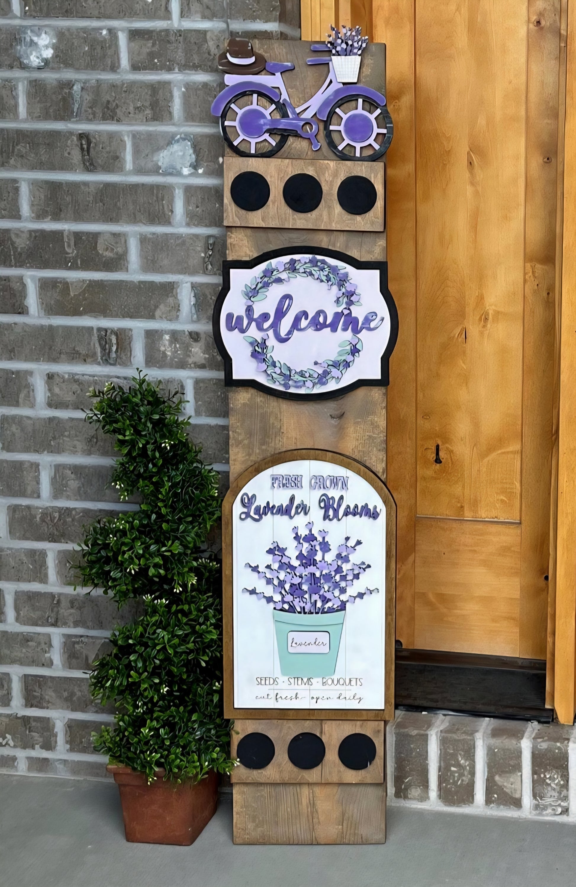 Decorative sign with lavender theme and 'welcome' text on a brick wall background